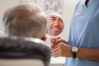 dental patient smiling in mirror