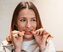 Patient putting on clear aligner in treatment room