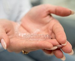 Closeup of patient holding clear aligner