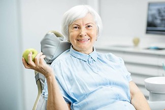 senior dental patient with apple