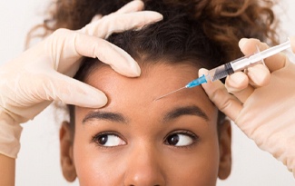 a person receiving a BOTOX injection in their forehead