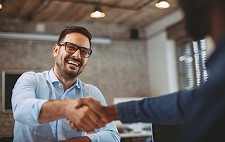 Man shaking hands while discussing cost of cosmetic dentistry in Lincoln 