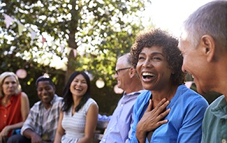 Diverse group of friends with dental implants in Lincoln laughing outside