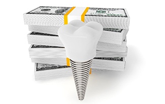 Model implant and stacks of money symbolizing cost of dental implants in Lincoln