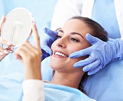 Young woman admiring her new dental implants in Lincoln