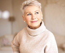 Woman with dental implants in Lincoln smiles while looking off