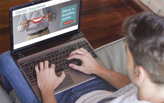 Man looking at dental insurance on laptop