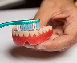 Man brushing dentures