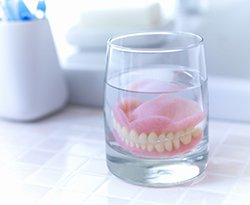 Dentures soaking in a glass