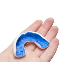 blue mouthguard in a person’s hand