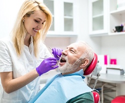 dental hygienist cleaning a patient’s teeth