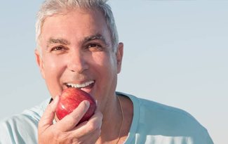 Senior man eating apple