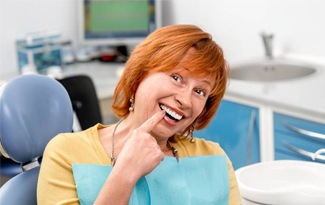 Senior woman pointing to flawless smile