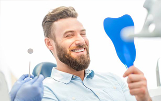 Man looking at smile in mirror