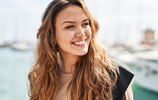 Closeup of woman with white teeth smiling outside