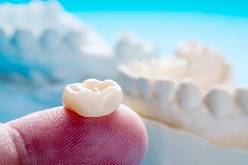 Close-up of prosthodontist in Lincoln holding crown on finger