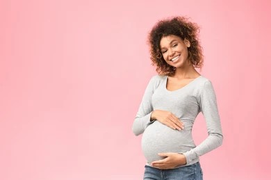 pregnant person pointing to their smile