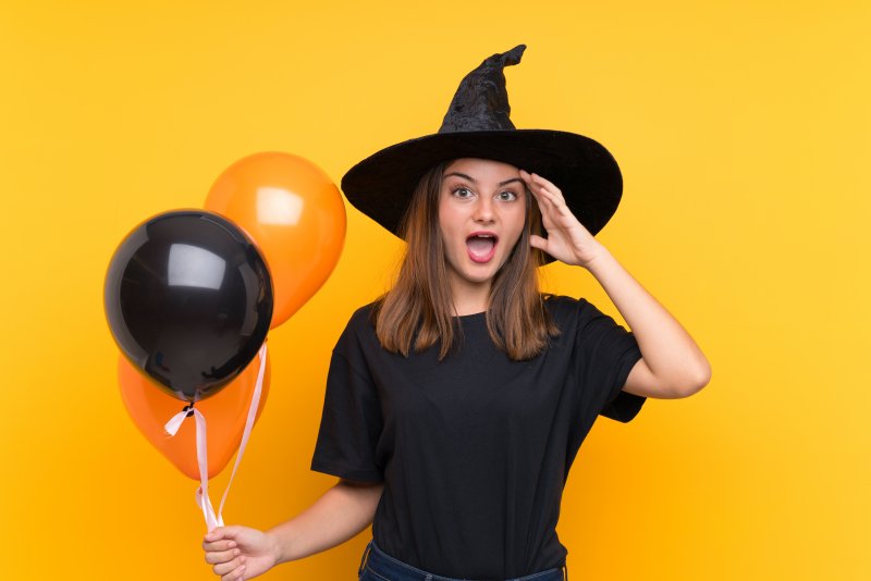 woman in witch hat surprised at oral health in Lincoln