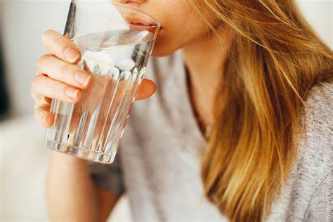 person drinking water to prevent winter mouth issues