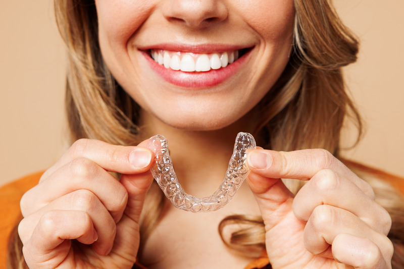Patient putting on their Invisalign aligner