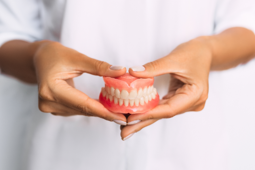 Close up of hands holding dentures